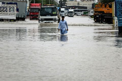Ein Mann in Dubai watet durch das Wasser