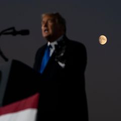 Donald Trump spricht vor dunkler Kulisse, hinter ihm ist der Mond zu sehen