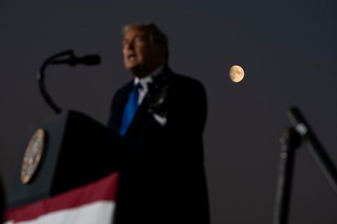 Donald Trump spricht vor dunkler Kulisse, hinter ihm ist der Mond zu sehen