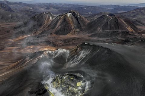 Wie eine eiternde Wunde klafft der Vulkankrater auf dem Gipfel des Isluga, der sich über der kahlen Landschaft des Altiplano an der Grenze zwischen Chile und Bolivien erhebt. Gasschwaden treten aus seinem Inneren; gelb gefärbtes Gestein an den Kraterwänden bezeugt die Schwefelvorkommen, die hier vor einigen Jahrzehnten noch abgebaut wurde. Bernhard Edmaier fotografierte den gewaltigen Krater mit einem Durchmesser von 400 Metern aus der Vogelperspektive und dabei Wissenschaft und Kunst vereint. Der Fotograf und Geologe zeigt mit seinen spektakulären Luftaufnahmen im Bildband "Elements", mit welcher Macht die Natur Landschaften formt – nicht nur hier, in der Hochebene der Anden, sondern auf allen Kontinenten 