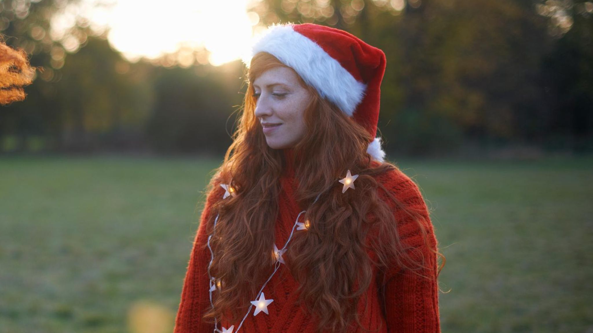 Eine junge mit einer Nikolaus-Mütze Frau blickt traurig