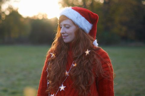 Eine junge mit einer Nikolaus-Mütze Frau blickt traurig