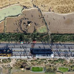 Ein Bagger hebt eine Grube aus, um den Kadaver eines Elefanten zu begraben, der bei der Kollision mit einem Zug ums Leben kam. F