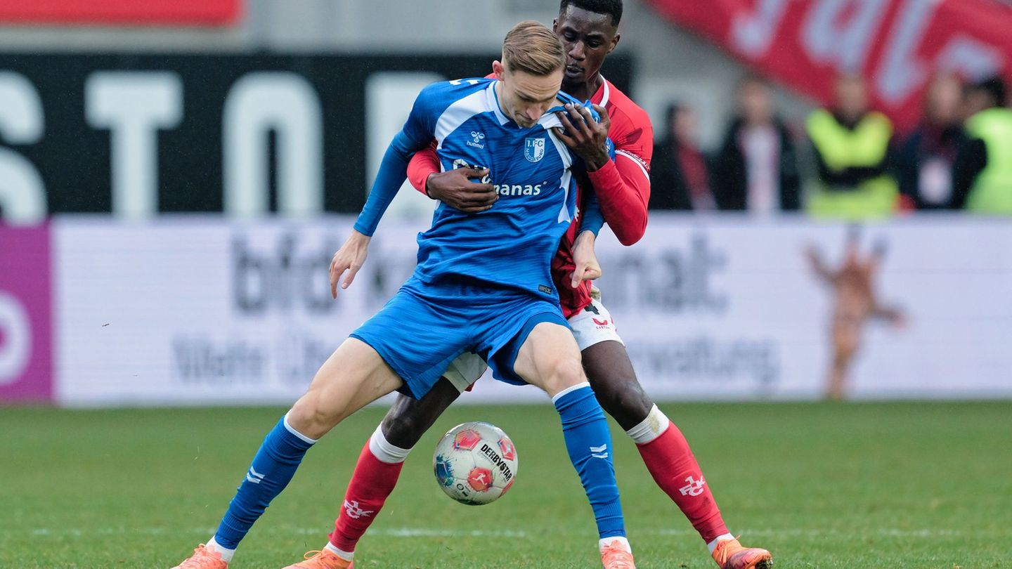 Maximilian Breunig (Magdeburg) und Maxwell Gyamfi (1. FC Kaiserslautern) kämpfen um den Ball. Foto: Uwe Anspach/dpa