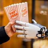 Berlin, Deutschland. Dieses Bild sieht aus, als stamme es aus dem Film "I, Robot". Doch es ist Realität: Der humanoide Roboter "Optimus" von Tesla verteilt bei seiner Vorstellung in der Mall of Berlin Popcorn an einem Weihnachtsmarktstand