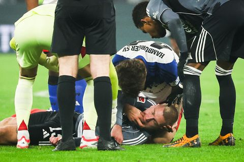 HSV-Verteidiger Luka Vuskovic hilft dem am Boden liegenden Eintracht-Profi Rasmus Kristensen. Foto: Christian Charisius/dpa