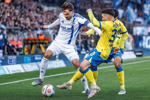 Die Braunschweiger Johan Gomez (verdeckt, Eintracht Braunschweig) und Robin Heußer bedrängen den Schalker Kenan Karaman (l). Fot