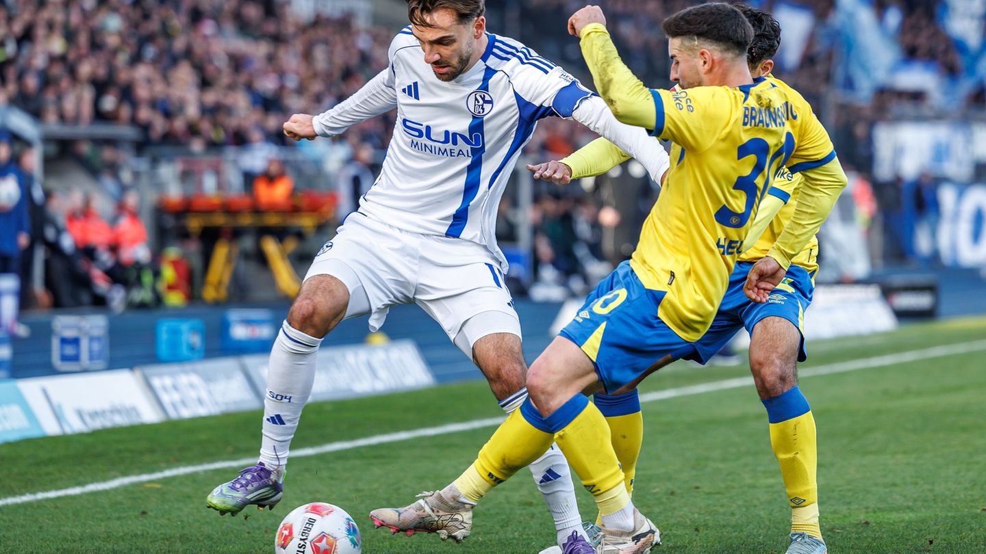 Die Braunschweiger Johan Gomez (verdeckt, Eintracht Braunschweig) und Robin Heußer bedrängen den Schalker Kenan Karaman (l). Fot
