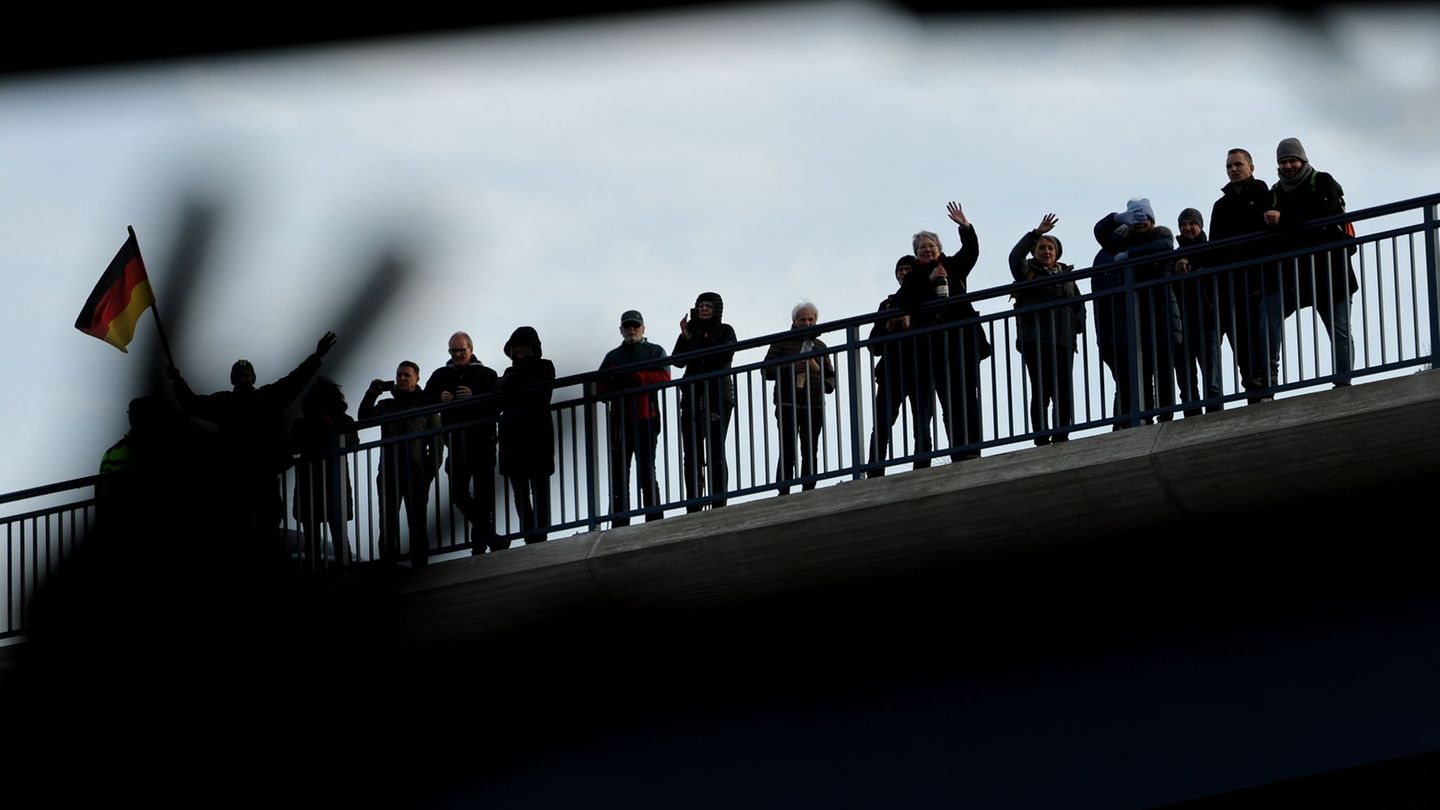 Schaulustige, die auf einer Brücke in der Nähe der Rahmedetalbrücke stehen, winken nach der Eröffnung einem Bus, der über die Br