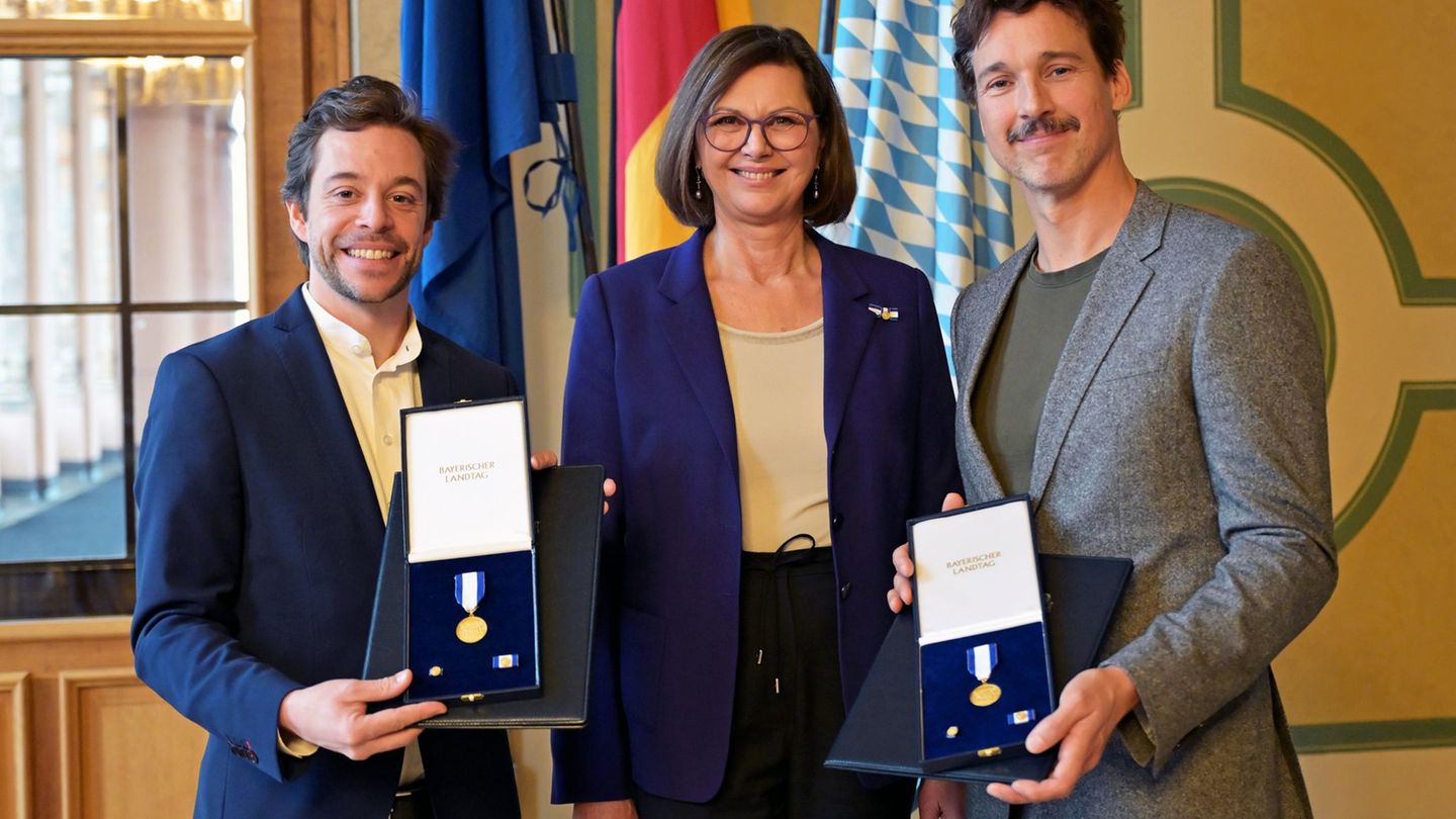 Landtagspräsidentin Ilse Aigner (CSU) zeichnet Tobias Krell und Florian David Fitz bei einem Nachholtermin mit dem Bayerischen V