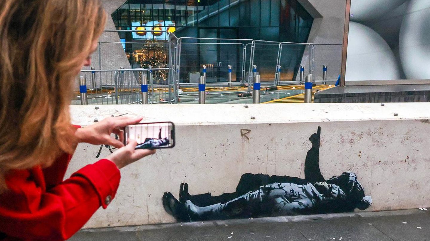 London, England. Mit zwei neuen, nahezu identischen Graffitis hat der britische Künstler Banksy für Aufsehen gesorgt. Die Werke zeigen jeweils ein Kind mit Mütze und Gummistiefeln, das neben einer anderen Person liegt, die in den Himmel zeigt. Das eine Graffiti wurde nahe der Tottenham Court Road entdeckt (Bild), das andere in Bayswater nördlich vom Kensington-Park