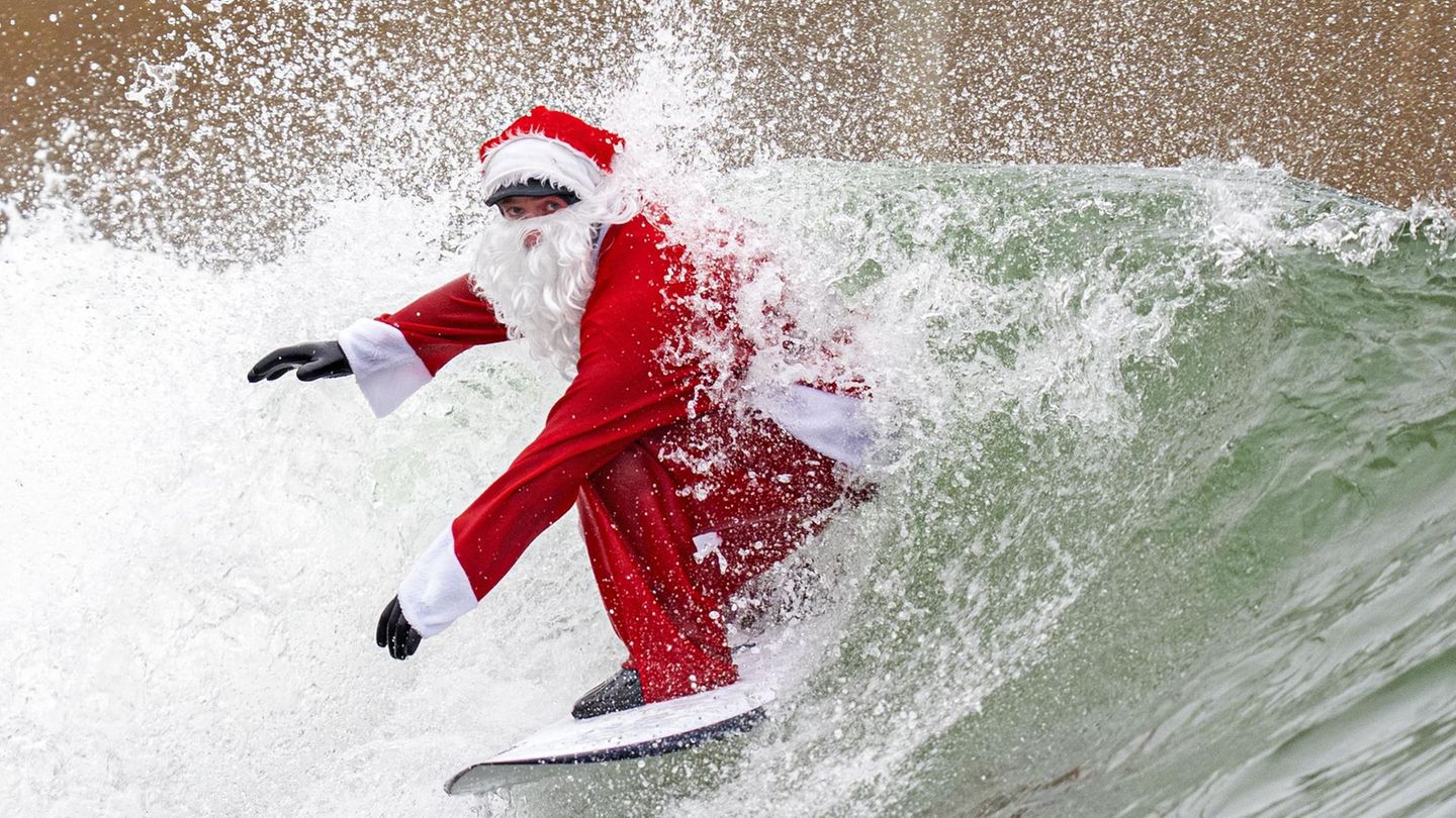 Edinburgh, Großbritannien. Board statt Schlitten: Im schottischen Lost Shore Surf Resort in Newbridge, in der Nähe von Edinburgh reitet ein als Weihnachtsmann verkleideter Surfer eine Welle 