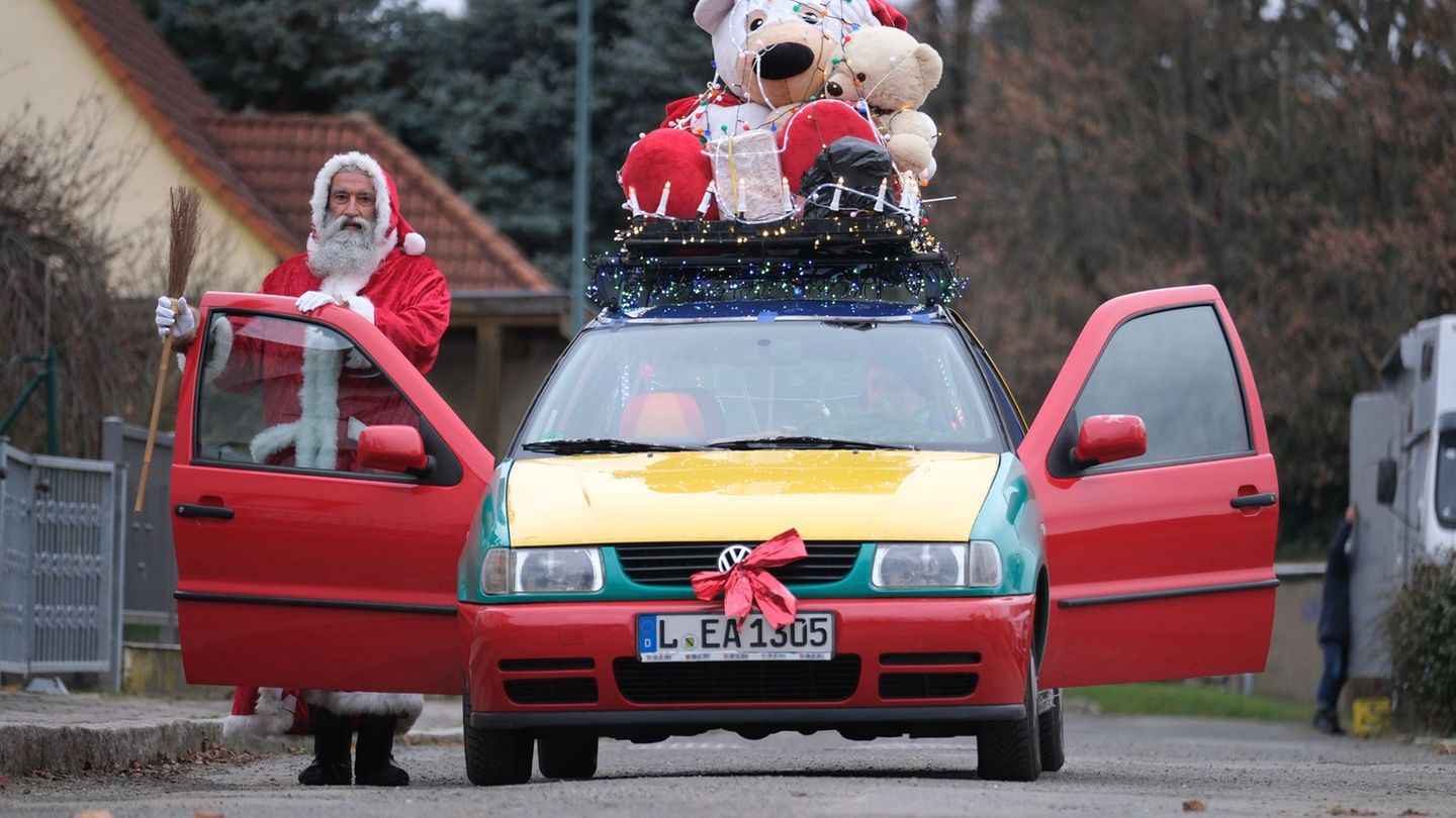 André Adelinia ist als Leipziger Weihnachtsmann mit einem reich dekorierten Auto unterwegs. Foto: Sebastian Willnow/dpa