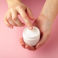 Gut für die Haut? Frauenhände halten eine Cremetiegel