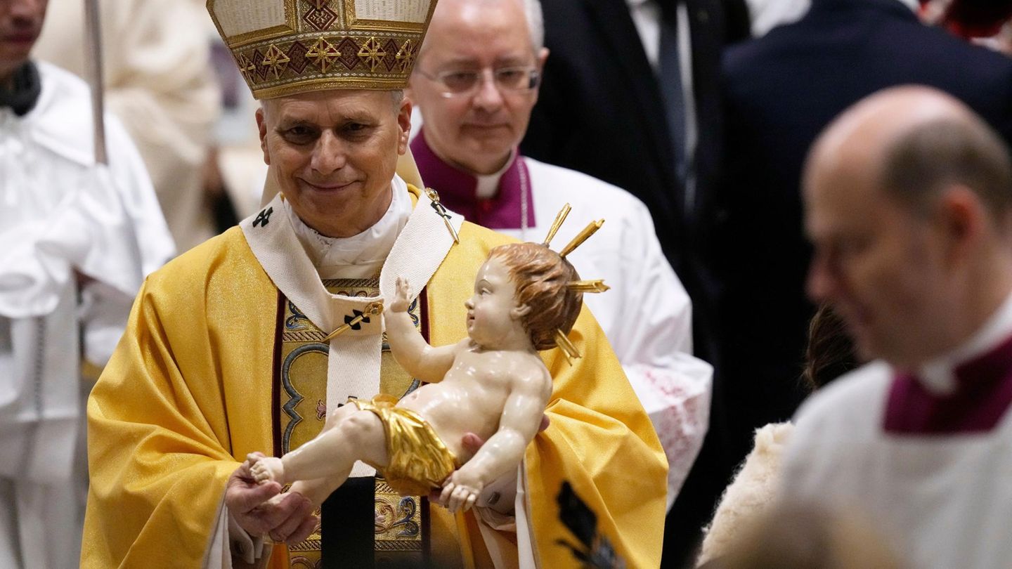 Papst Leo XIV. trägt die Figur des Jesuskindes bei der Messe im vollbesetzten Petersdom