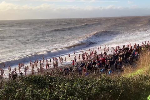 Wohl hunderte Menschen warten am Strand von Budleigh Salterton, Großbritannien, auf das Weihnachtsschwimmen