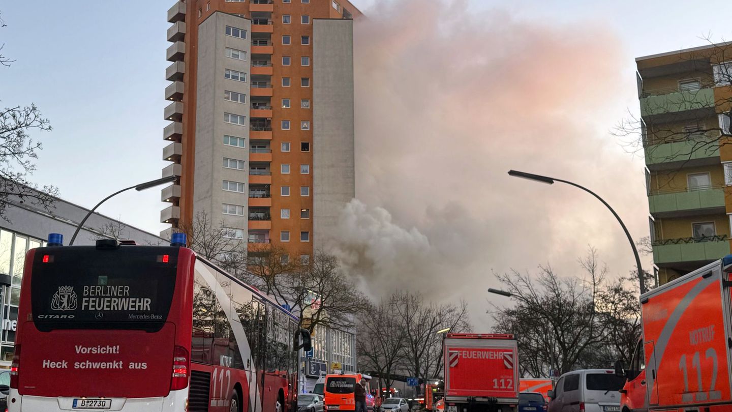Rettungskräften vor dem brennenden Hochhaus in Berlin-Spandau. Foto: Sven Käuler/dpa