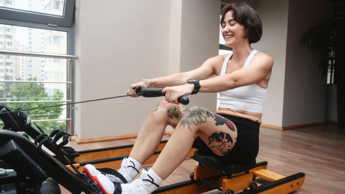 Eine Frau trainiert auf einem Rudergerät.