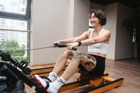 Eine Frau trainiert auf einem Rudergerät.