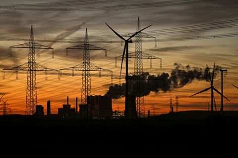 Strommasten und Windturbine vor Kraftwerk bei Neurath