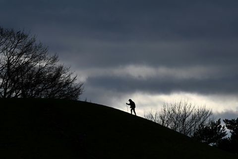 Mensch beim Nordic Walking unter wolkigem Himmel