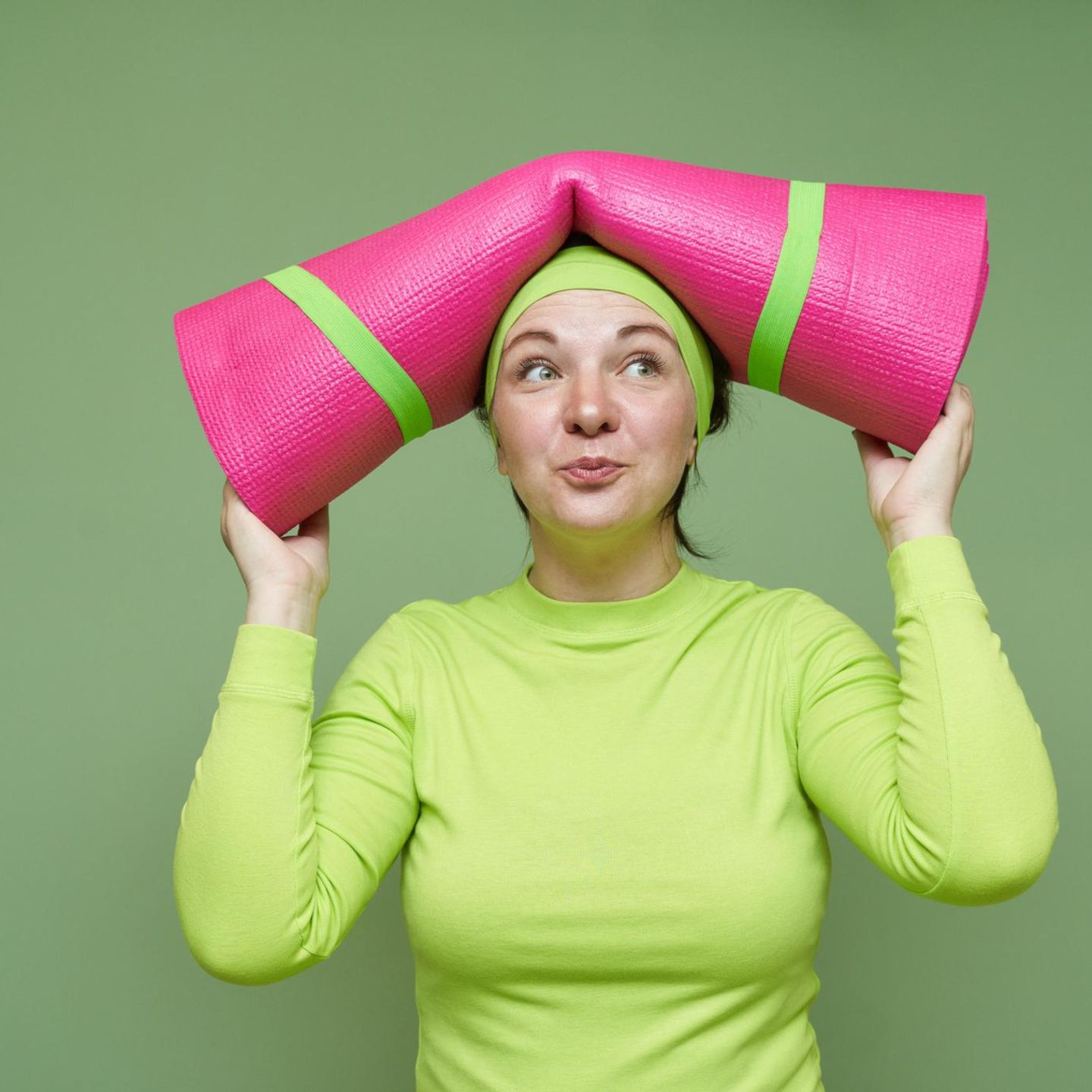 Gesund leben: eine Frau mit Yoga-Matte auf dem Kopf