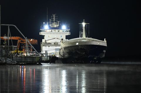 In einem Hafen in Finnland liegt das Schiff "Fitburg", ein schwarzer Frachter mit weißen Aufbauten (Bild Unterseekabel)