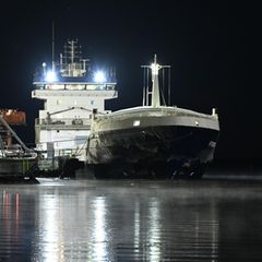 In einem Hafen in Finnland liegt das Schiff "Fitburg", ein schwarzer Frachter mit weißen Aufbauten (Bild Unterseekabel)