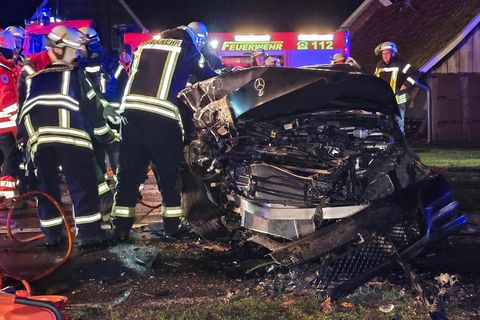 Einsatzkräfte am stark beschädigten Unfallfahrzeug im Landkreis Osnabrück. Foto: -/NWM-TV/dpa