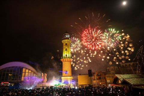 Zahlreiche Menschen haben am Neujahrstag das traditionelle Warnemünder Turmleuchten an der Strandpromenade des Ostseebades verfo