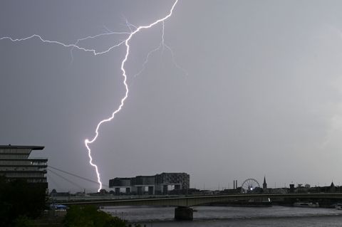 Ein Blitz zuckt bei einem Gewitter über dem Himmel über dem Kölner Süden. (Archivbild) Foto: Henning Kaiser/dpa
