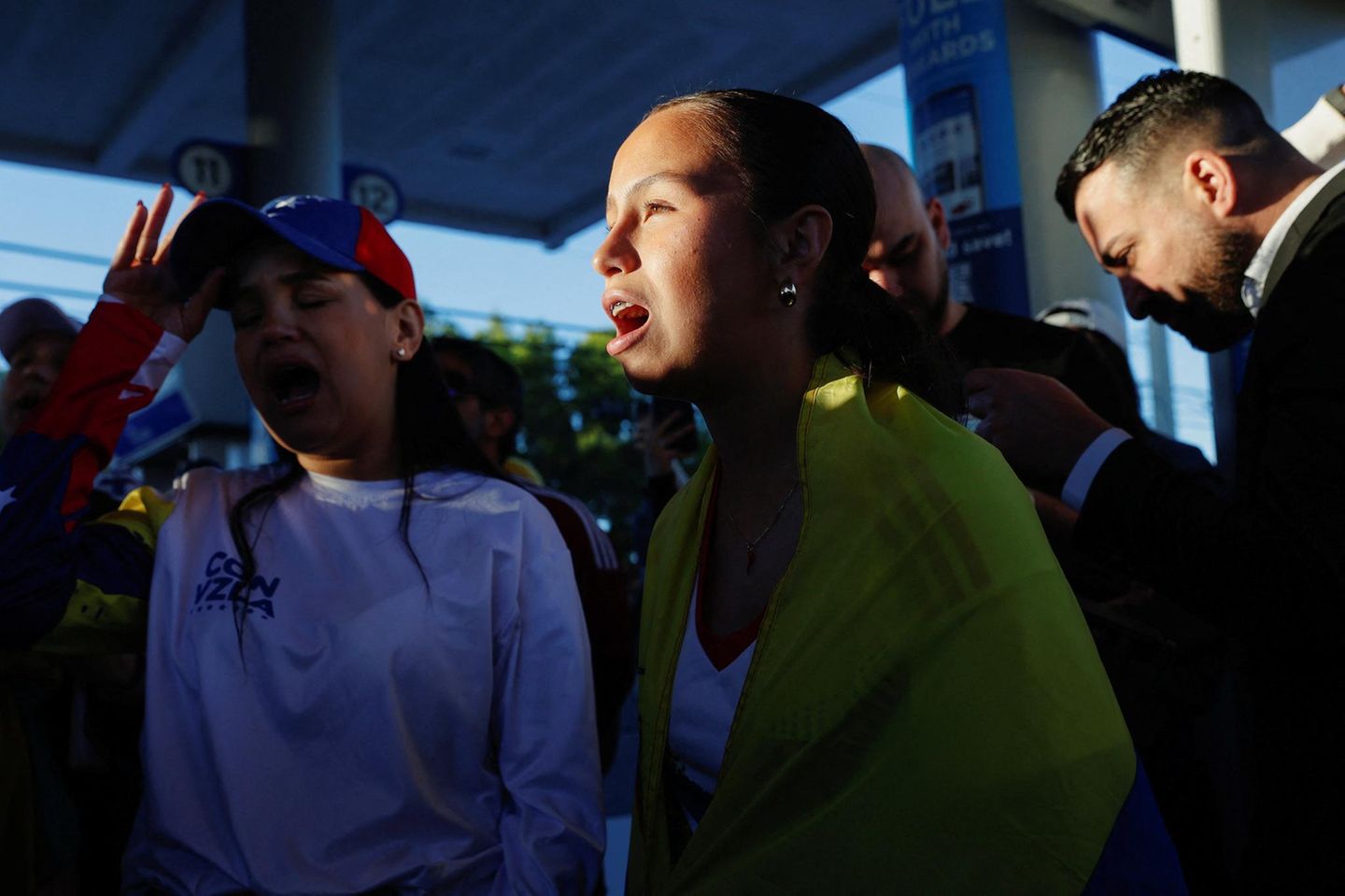 Zwei Mädchen mit venezolanischer Flagge blicken erstaunt