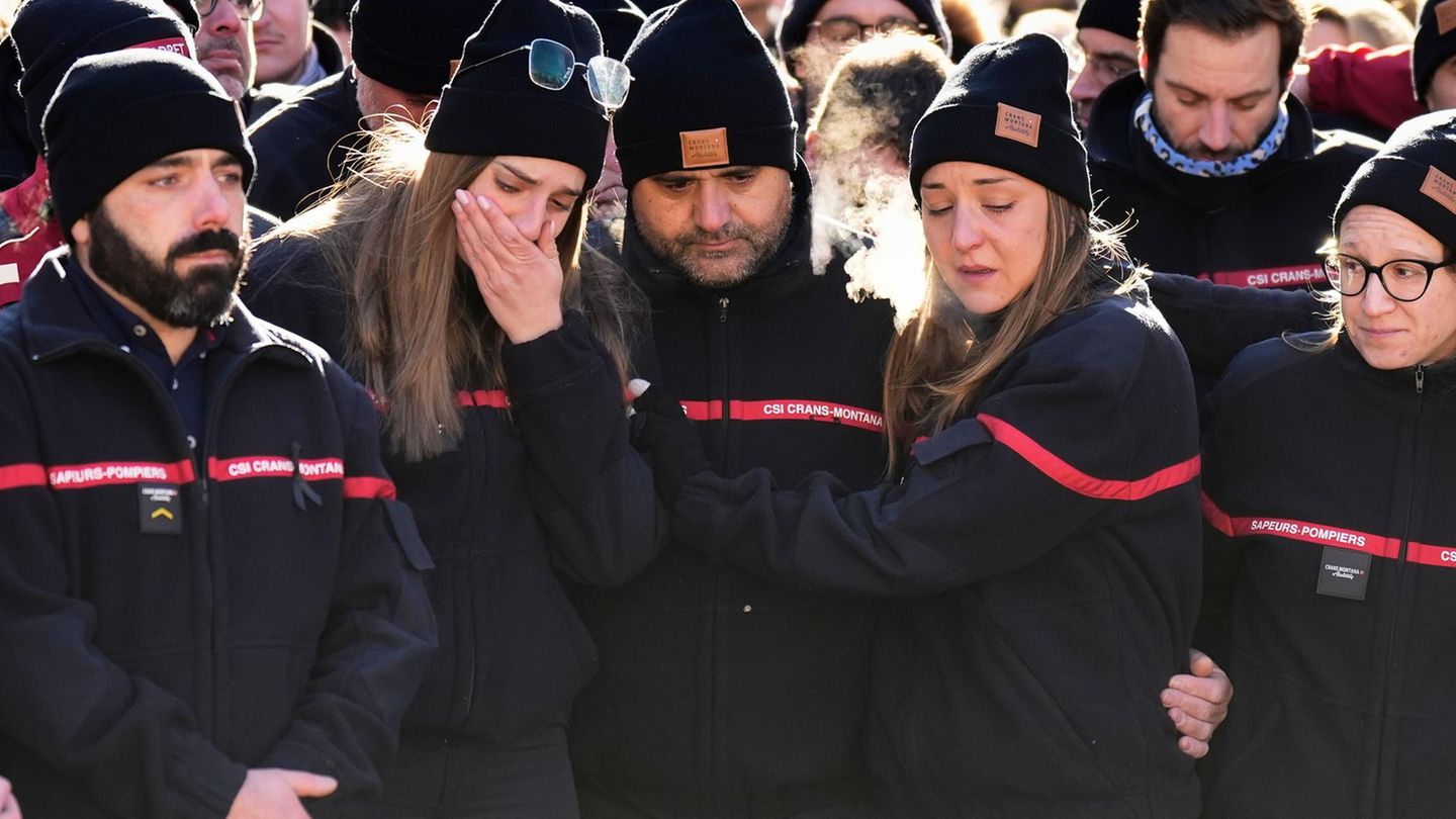 Feuerwehrleute trauern nach einer Sonntagsmesse in der katholischen Kapelle, um die Opfer des Brandes in der Bar "Le Constellation" in Crans-Montana