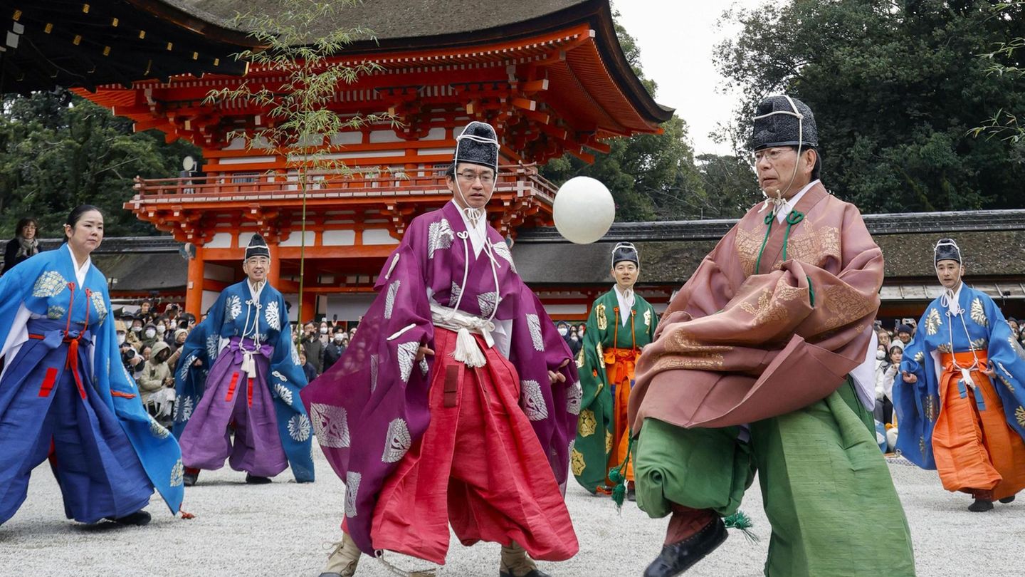 Japaner spielen in traditioneller Kleidung Fußball