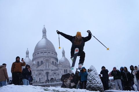 Paris: Ein Mann springt mit seinen Skiern den Hügel bei der Basilika Sacre-Coeur hinunter