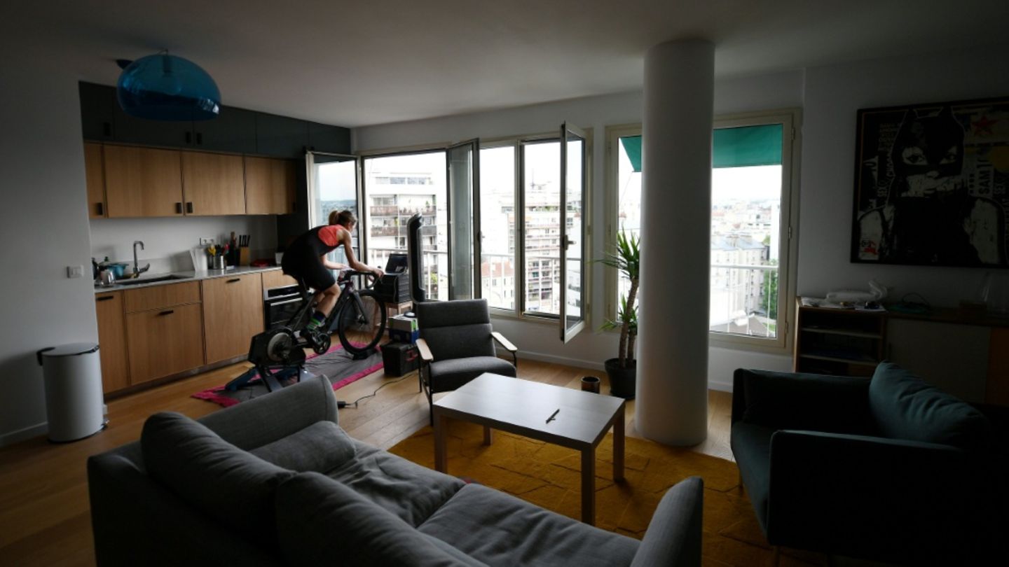 Frau auf einem Hometrainer in Wohnzimmer