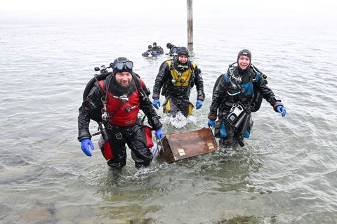 Taucherinnen und Taucher haben die hölzerne Schatzkiste im Bodensee gefunden. Foto: Felix Kästle/dpa