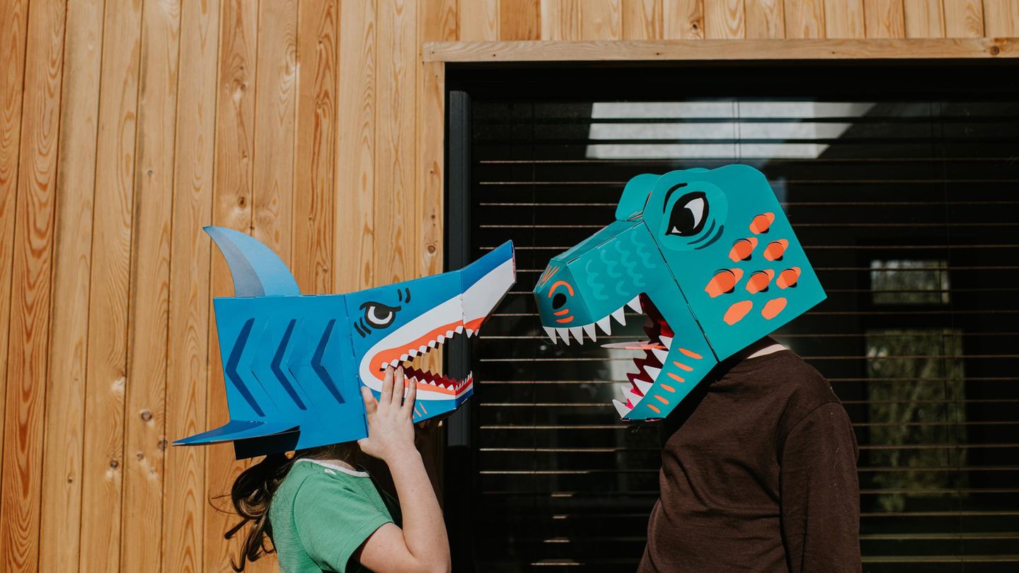 Zwei Kollegen mit Dinosauriermasken auf dem Kopf streiten