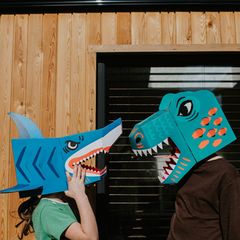 Zwei Kollegen mit Dinosauriermasken auf dem Kopf streiten