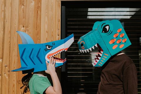 Zwei Kollegen mit Dinosauriermasken auf dem Kopf streiten