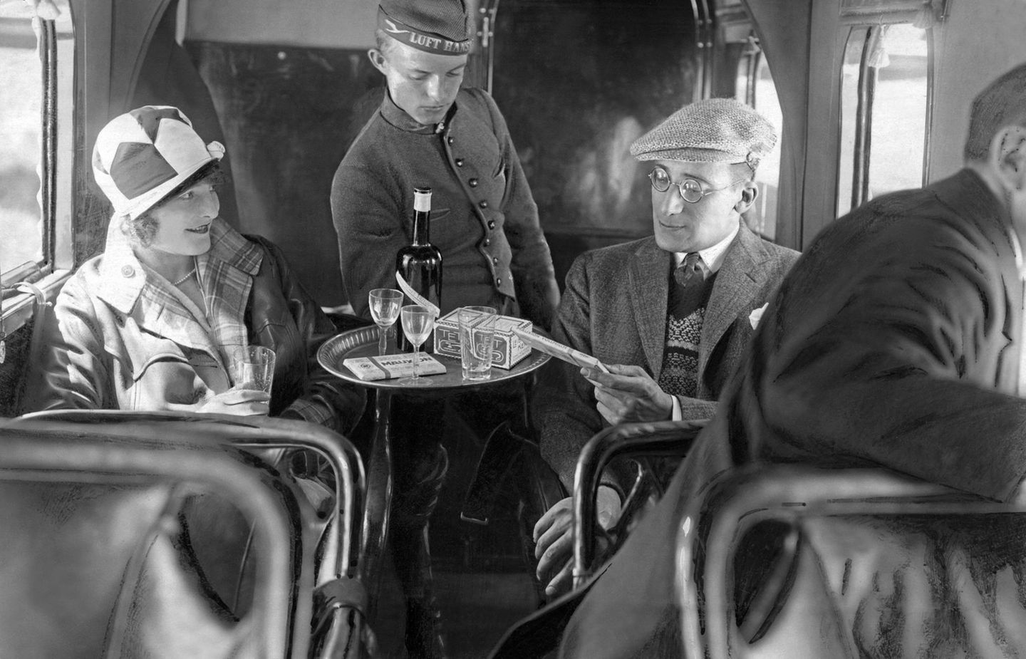 Ein Stewart in Livree bedient in einer Lufthansa-Maschine , um 1930