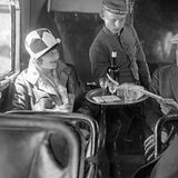 Ein Stewart in Livree bedient in einer Lufthansa-Maschine , um 1930