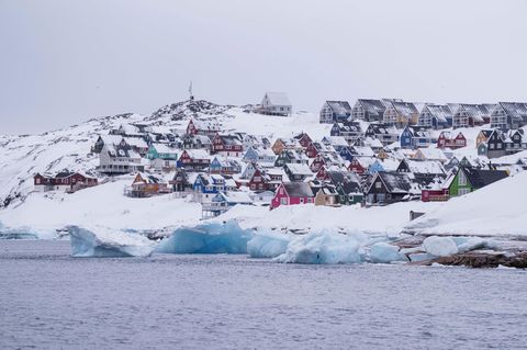 In Nuuk auf Grönland sind schneebedeckte Häuser vom Meer aus zu sehen