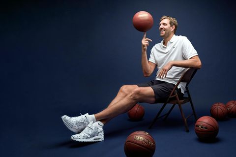 Dirk Nowitzki sitzt auf einem Stuhl und spielt mit Basketbällen