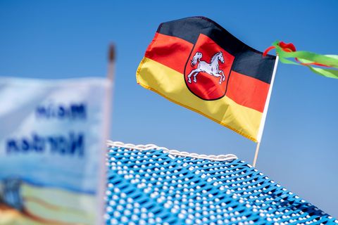 Eine Flagge dem Wappen von Niedersachsen weht auf einem Strandkorb auf Borkum. (Symbolbild) Foto: Hauke-Christian Dittrich/dpa