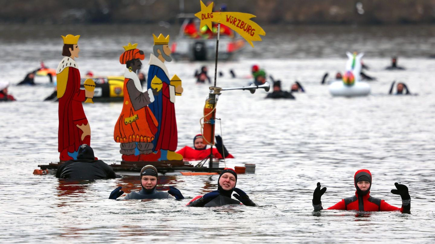 Teilnehmer des 40. Drei-König-Schwimmens treiben im Wasser des Mains. Foto: Karl-Josef Hildenbrand/dpa