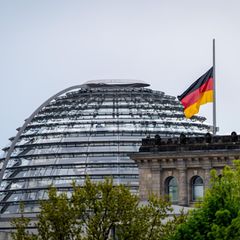 Eine Flagge weht auf Halbmast auf dem Reichstaggebäude vor der Reichstagskuppel