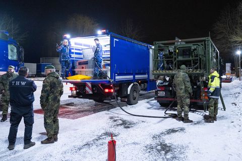 Ein Kraftstoffcontainer vom Technischen Hilfswerk THW wird auf einem Betriebshof vom THW von einem Tankwagen der Bundeswehr geta