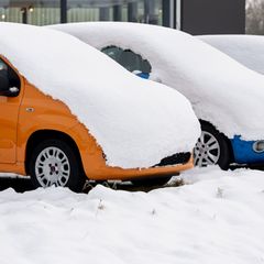 Parkende Autos verschwanden unter einer dicken Schneedecke. Foto: Hauke-Christian Dittrich/dpa