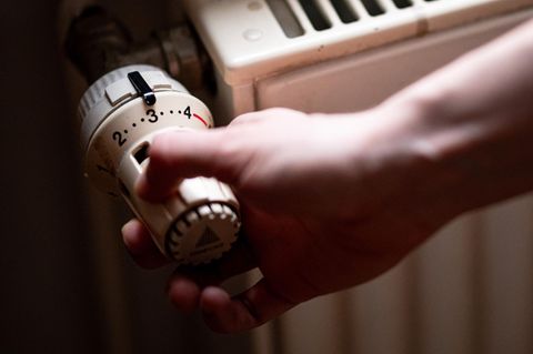 Eine rechte Hand dreht ein Heizungsventil auf 3 – Symbolbild Gasspeicher